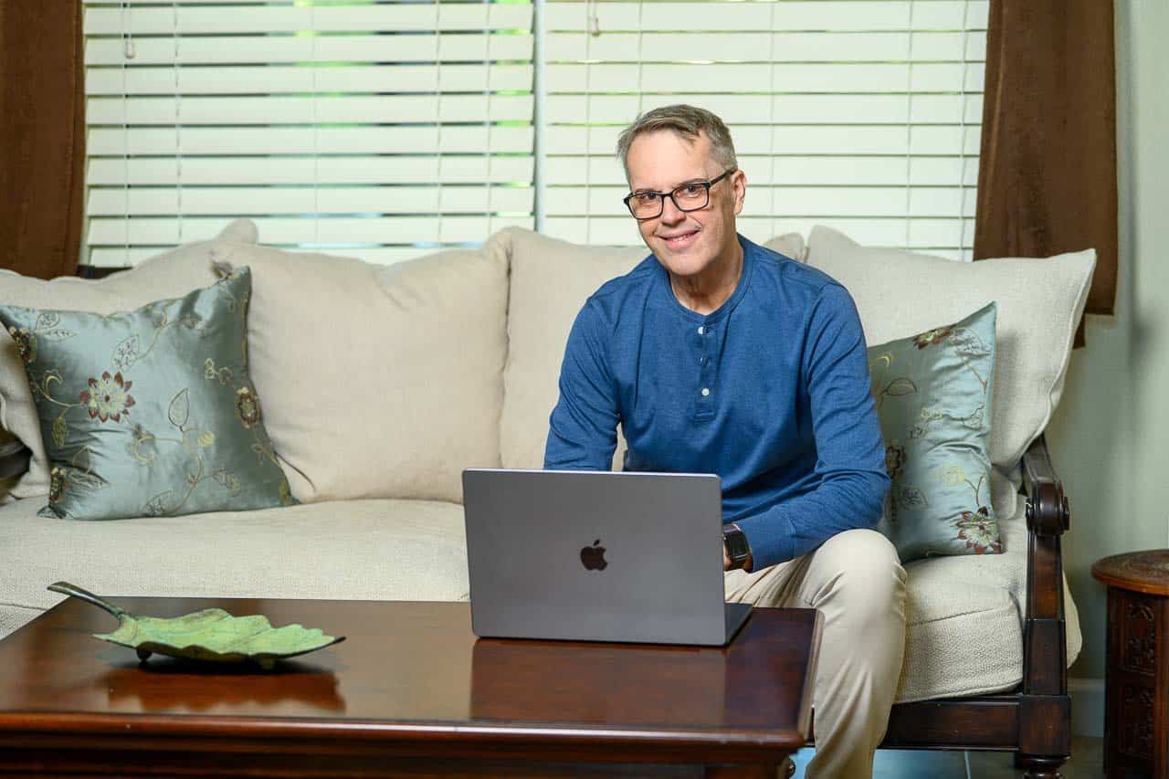 William Beem on couch with laptop for Website Conversion Academy